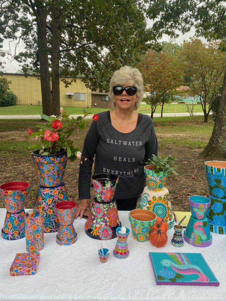 Small Business owner Patti stands behind her decorative pots display