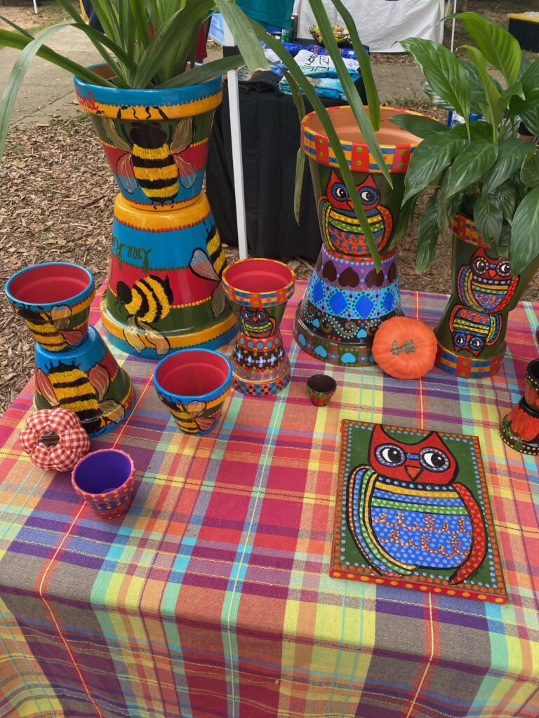 Hand painted terracotta pots on display at a local farmer's market.