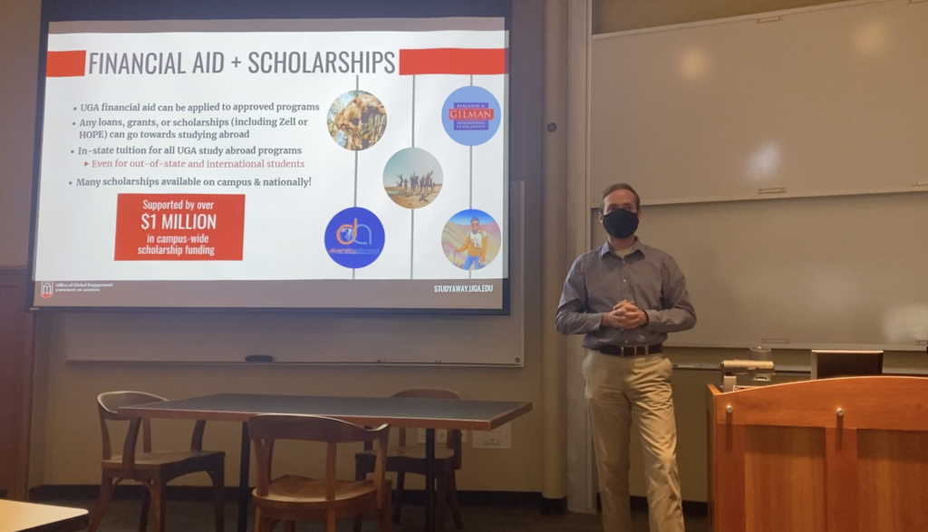 A student stands in front of large screen giving a presentation on study away scholarships